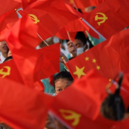 Students wave the flags of China and the Communist Party before celebrations in Beijing on July 1 to mark the 100th anniversary of the founding of the Communist Party of China. Photo: AFP 