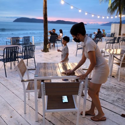 Esther Lee, owner of the Hidden Langkawi restaurant, cleans a table at her restaurant as Langkawi gets ready to open to domestic tourists from September 16. Photo: Reuters