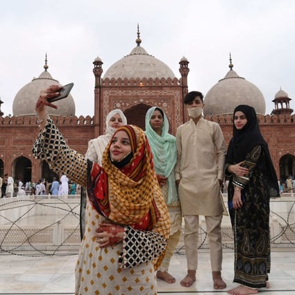 A woman takes a selfie with her friends after offering prayers at Badshahi Mosque during Eid al-Adha, the Festival of Sacrifice, in Lahore, Pakistan, on July 21. Out of Pakistan’s population of over 221 million, some 64 per cent are under the age of 30.  Photo: AFP