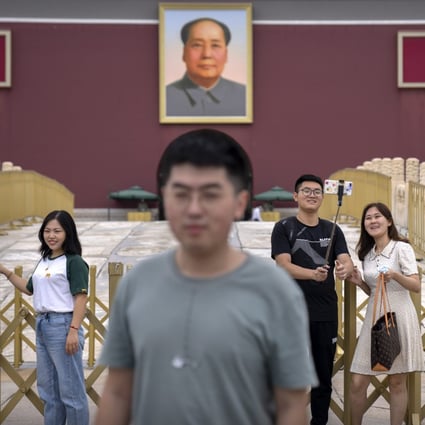 Visitors pose for photos near the large portrait of Chinese leader Mao Zedong on Tiananmen Gate next to Tiananmen Square in Beijing on September 18. Photo: AP