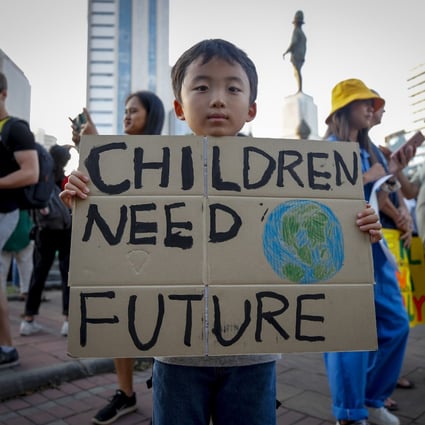 A young boy holds a sign outside a park during a climate change strike in Bangkok, Thailand, on November 29, 2019. Photo: EPA-EFE