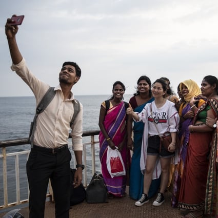 A Chinese tourist gets a picture taken with Sri Lankans on the Galle Face Green in Colombo in November 2019. Photo: Getty Images