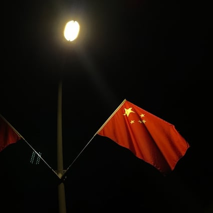 Chinese flags lit by street lamps at night in a park in Shenzhen on September 29. China will quickly overcome the power shortages, but developing a more resilient, sustainable energy sector will take time. Photo: Bloomberg