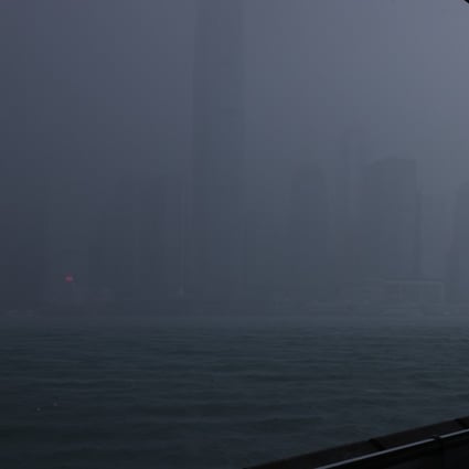 A woman looks out across Victoria Harbour as the Hong Kong Observatory issues the first typhoon warning No 1 signal in 2021 on June 11. In October, Hong Kong issued two No 8 storm warning signals in four days. Photo: Dickson Lee