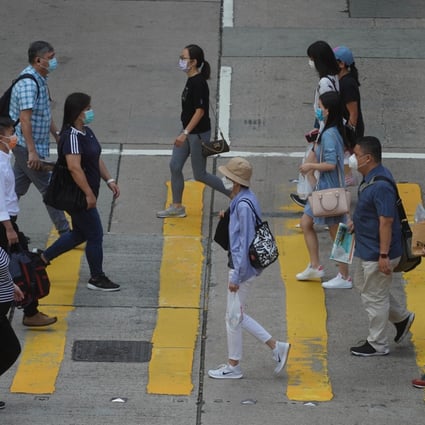 People cross a road in Central. Hong Kong’s workforce continues to contract, to around 3.84 million, down from a peak of 3.97 million in the spring of 2019. Photo: Winson Wong