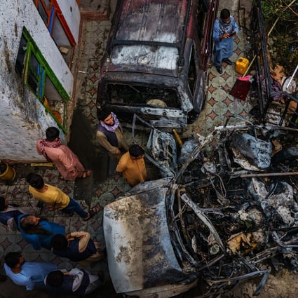 Relatives and neighbours of the Ahmadi family gather around the wreckage of a vehicle that the family says was hit by a US drone strike in Kabul, Afghanistan, on August 30. Photo: TNS
