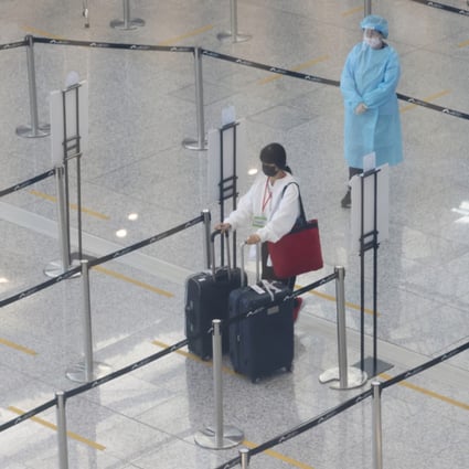 A traveller arriving at Hong Kong airport on November 14 waits in line for transport to a quarantine hotel. Photo: May Tse
