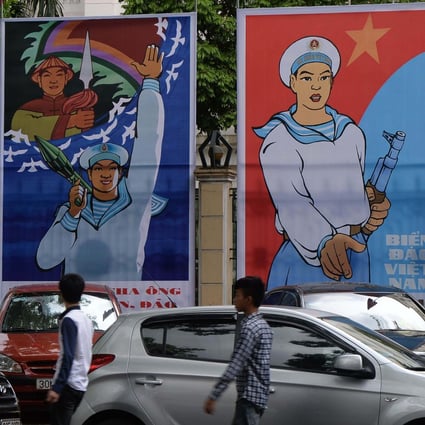 Young people walk past propaganda billboards highlighting Vietnam’s determination to defend its coastal waters and islands, in Hanoi on May 27, 2014. Photo: AFP