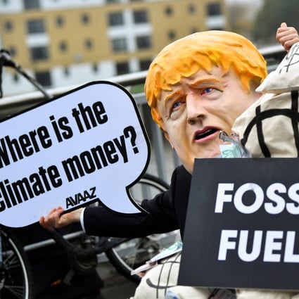 A person wearing a mask depicting Britain’s Prime Minister Boris Johnson protests during COP26 in Glasgow, Scotland, on November 12. An effective carbon trading system is a necessary tool in the transition to a net-zero economy. Photo: Reuters