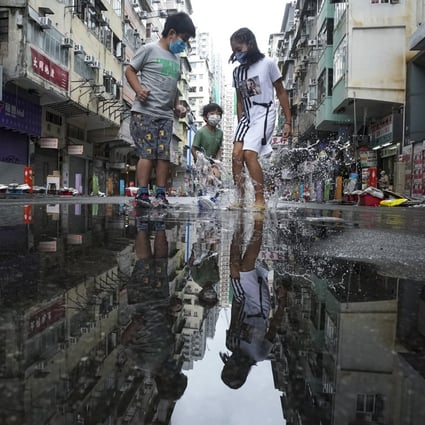 Children splash in puddles on Tung Choi Street on October 13. In rich and peaceful Hong Kong, every child should be happily going to school, getting a good education and playing with their peers. Photo: Felix Wong