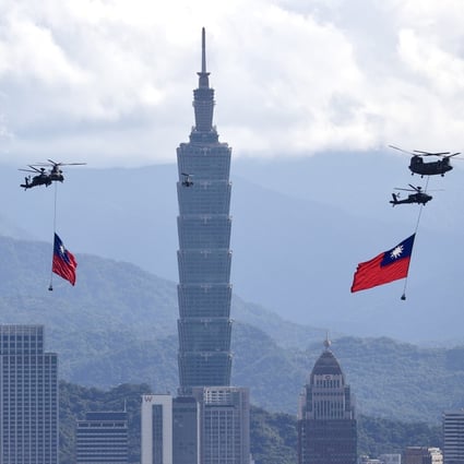 Helicopters trailing the Taiwan flag fly past the Taipei 101 tower. Photo: EPA-EFE