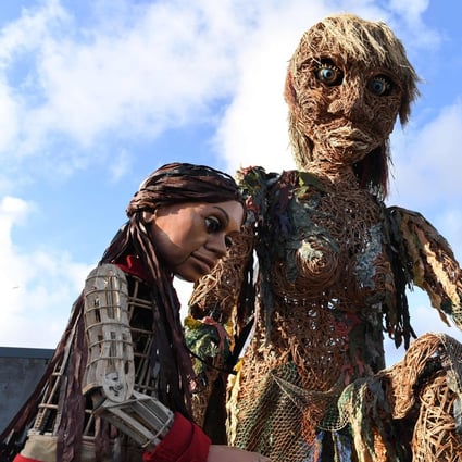 Storm, (R), a 10-metre tall “goddess of the sea” puppet who carries a message of the oceans in crisis, meets Little Amal, a 3.5-metre tall Syrian refugee puppet in Glasgow in November 2021 during the Cop26 UN Climate Change Conference. Photo: AFP
