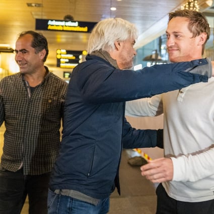 NRK journalists Halvor Ekeland (right) and Lokman Ghorbani (left) are received by head of NRK sports Egil Sundvor (C) after returning from Qatar. Photo: EPA