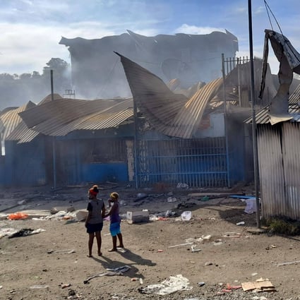 Smoke rises from a burnt out buildings in Honiara’s Chinatown on Friday after two days of rioting. Photo: AFP