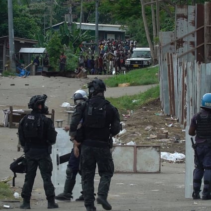 A frame grab from video footage shows Australian and local police officers patrol a street in Honiara on Friday. Photo: AFP
