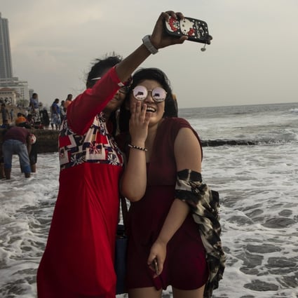 A Chinese tourist takes a selfie with a Sri Lankan friend in Colombo, Sri Lanka. The days of cheap and cheerful travel may have come to an end. Photo: Getty Images