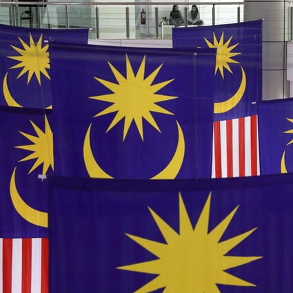 Women have a chat near giant Malaysian national flags inside a shopping mall in Bangi, outside Kuala Lumpur. Photo: EPA-EFE