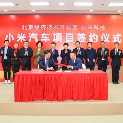 Xiaomi founder and CEO Lei Jun (left in front) signs a deal with local government officials to set up an electric vehicle factory at the Yizhuang economic development zone. Photo: Handout
