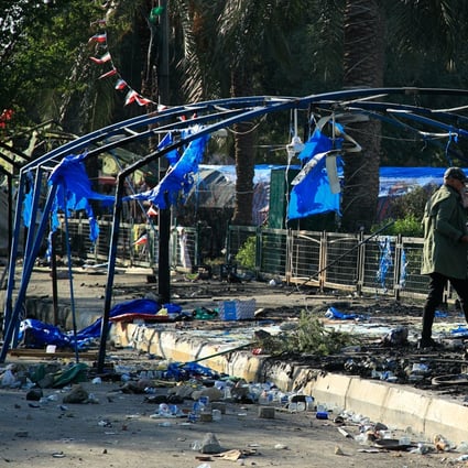 A man walks around burned tents outside the heavily fortified Green Zone in Baghdad, Iraq on Saturday. Photo: AP