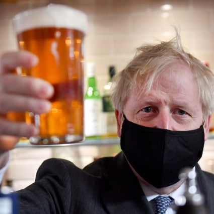 British Prime Minister Boris Johnson holding a pint of beer. Photo: Jacob King/PA Wire/dpa