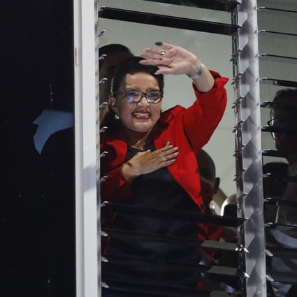 Honduras presidential candidate Xiomara Castro greets supporters from a window in Tegucigaloa after hearing the partial results of the elections. Photo: EPA