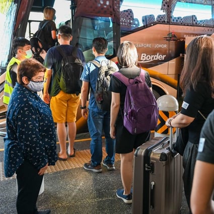 People board a bus in Singapore as a land border with Malaysia reopens on November 29, 2021. Photo: AFP 