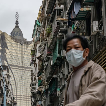 A man wearing protective mask walks across a street in front of the Grand Lisboa Hotel in Macau. Photo: Getty Images