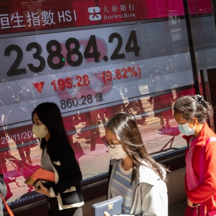 People walk past an electronic board displaying the Hang Seng Index on November 29. Photo: EPA-EFE