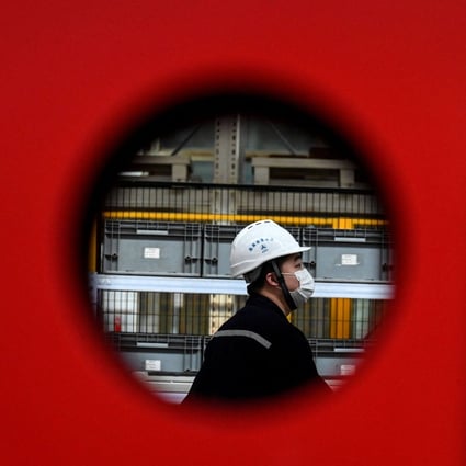 An employee works on a machine production line at a factory in Beijing on October 15. While industrial output in China has been hit by power shortages, this shock is likely to be short-lived, unlike the more long-term impact of Covid-19. Photo: AFP