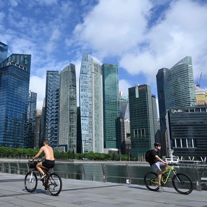 Cyclists ride their bicycles along the promenade at Marina Bay. Singapore rose by two points in the EIU cost of living report. Photo: AFP