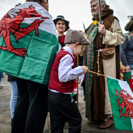 People wear traditional dress and carry the Welsh flag during a St David’s Day Parade in Cardiff in 2019. With a rise in Welsh pride has come renewed interest in the Welsh language, which the English repressed for centuries. Photo: Getty Images
