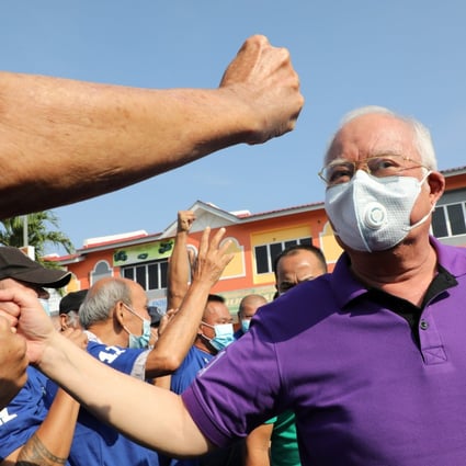 Former Malaysian prime minister Najib Razak gives a fist bump to a supporter on the campaign trail. Photo: Reuters