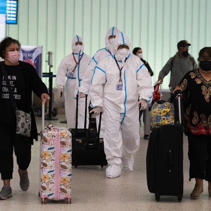 Air China flight crew members in hazmat suits walk through the arrivals area at Los Angeles International Airport in Los Angeles, Tuesday, Nov. 30, 2021. Photo: AP