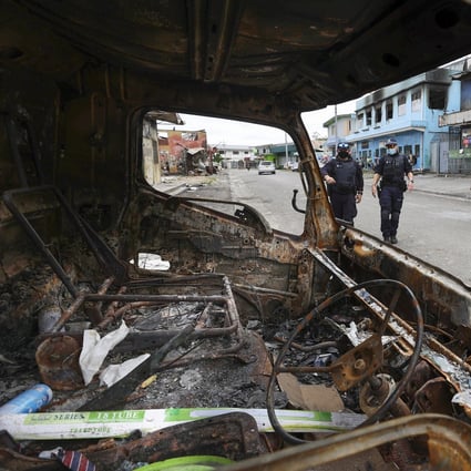 Australian Federal Police inspect burnt out areas of Chinatown in Honiara on November 30. Photo: AP
