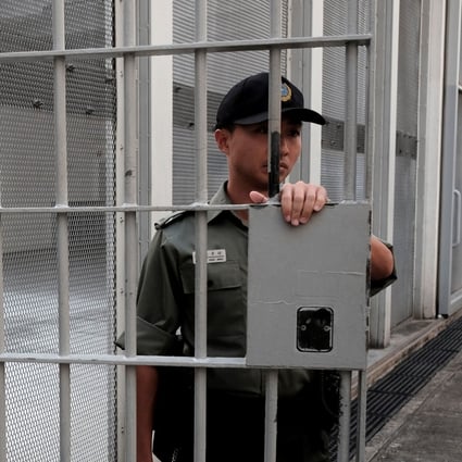 A Correctional Services Department officer holds a gate at Lai Chi Kok Reception Centre, a maximum security institution, in 2018. Photo: Reuters