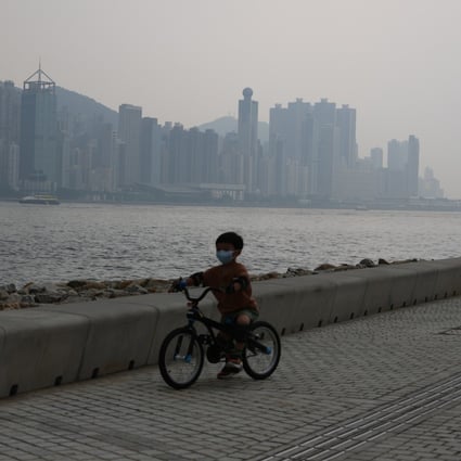 A child rides a bicycle along the West Kowloon waterfront on June 6, amid higher than normal  levels of pollution. Photo: May Tse
