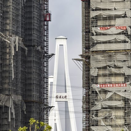 Scaffolding netting damaged by Typhoon In-Fa shrouds buildings at a residential development under construction in Shanghai on July 29. Chinese policymakers are walking a tightrope as they seek to balance the need to rein in leverage in the property sector with the fallout of the near-collapse of China Evergrande Group and other developers. Photo: Bloomberg
