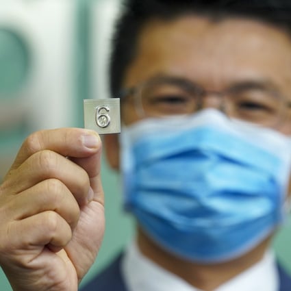 University of Hong Kong Professor Huang Mingxin displays a lift button and a sample piece made from a new stainless steel designed to kill coronavirus cells. Photo: Sam Tsang