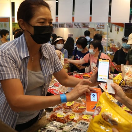 A woman uses an e-voucher, distributed as part of a government scheme to boost the economy, at the Hong Kong Brands and Products Shopping Expo at AsiaWorld-Expo on August 7. The e-vouchers gave many Hongkongers their first taste of e-payment. Photo: Winson Wong
