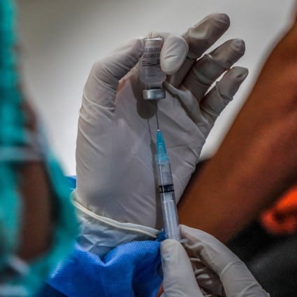 A health worker prepares to give a Covid-19 vaccine shot. Merriam-Webster and Oxford English Dictionary have chosen “vaccine” and “vax” as 2021’s words of the year. Photo: EPA-EFE