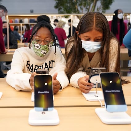 Young customers looks at iPhones at an Apple Store in Los Angeles in November. Photo: AP