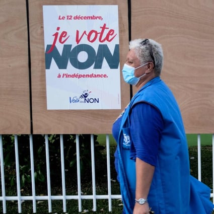 A woman walks past electoral boards in Noumea, New Caledonia, on December 10, 2021. Photo: AFP 
