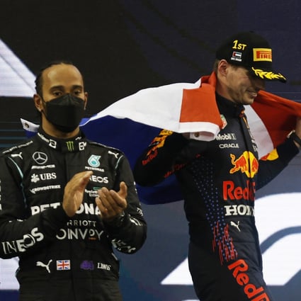 Max Verstappen celebrates winning the race and the world championship as Lewis Hamilton looks on after finishing second. Photo: Reuters