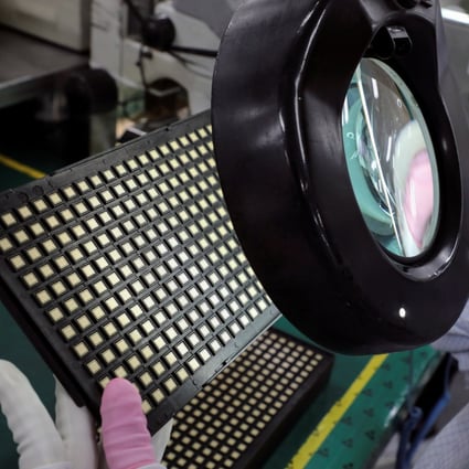 A worker inspects semiconductor chips at a plant in Ipoh, Malaysia, on October 15. Photo: Reuters
