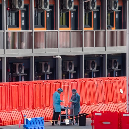 Staff members outside quarantine rooms at the Hong Kong government’s facility in Penny’s Bay, now a holding area for arrivals from countries with Omicron risks. Photo: Bloomberg