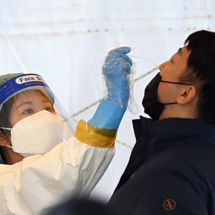 A nurse takes a nasal swab from a man at a Covid-19 testing centre in Seoul, as cases in South Korea reached record levels. Photo: AFP