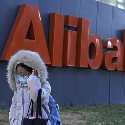 A woman wearing a face mask walks by the offices of Chinese e-commerce firm Alibaba in Beijing on December 13. Controversy over a former employee who accused a manager of rape was again inflamed after she said the company fired her last month for spreading “false information”. Photo: AP