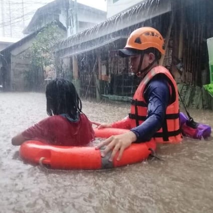 A member of the Philippine Coast Guard conducts a rescue operation during flooding caused by super typhoon Rai in Cagayan de Oro, southern Philippines. Photo: EPA-EFE
