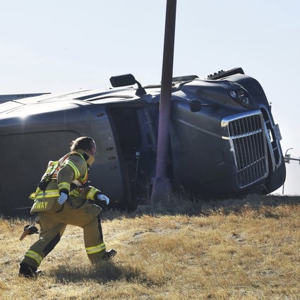 Paramedics tend to an injured person in Colorado Springs, Colorado, on Wednesday. Over a dozen large trucks were blown over by high winds in region. Photo: The Gazette via AP