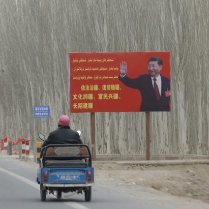 Chinese President Xi Jinping is seen on a billboard with the slogan, “Administer Xinjiang according to law, unite and stabilize the territory, culturally moisturize the territory, enrich the people and rejuvenate the territory, and build the territory for a long term,” in Yarkent County in northwestern China’s Xinjiang Uyghur Autonomous Region in March 2021. Photo: AP